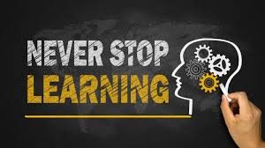 A black sign with the writing "never stop learning" and a picture of a head.