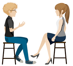 A male and female sitting on stools opposite each other having a conversation